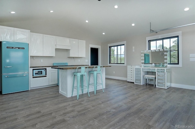 kitchen with light hardwood / wood-style flooring, white cabinets, and stainless steel appliances