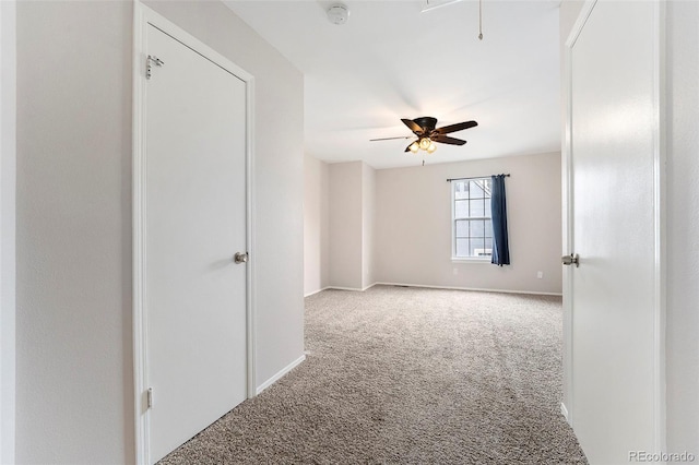 carpeted spare room with ceiling fan