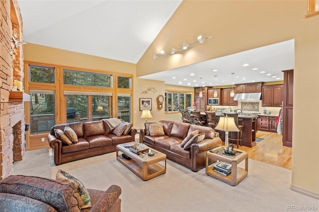 living area featuring high vaulted ceiling, a fireplace, and recessed lighting