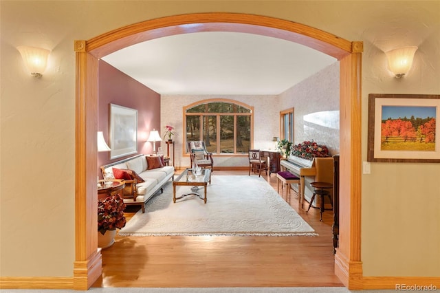 living room featuring arched walkways and wood finished floors