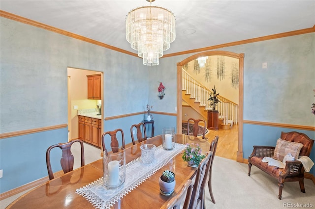 dining room featuring arched walkways, crown molding, baseboards, and an inviting chandelier