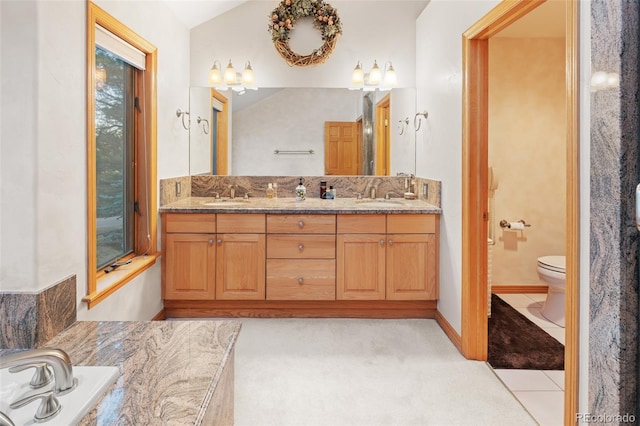 bathroom with tile patterned flooring, a sink, toilet, and double vanity