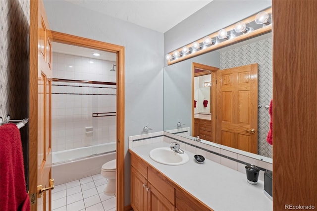 bathroom featuring tile patterned flooring, toilet, bath / shower combo with glass door, vanity, and decorative backsplash