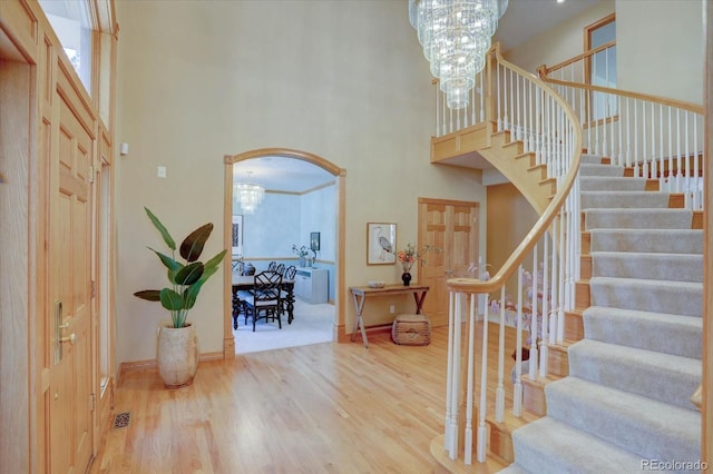 2828 Keystone Dr, Evergreen, CO 80439 - entrance foyer with a high ceiling, a chandelier, stairway, wood finished floors, and baseboards