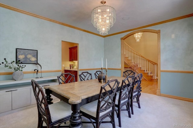 2828 Keystone Dr, Evergreen, CO 80439 - dining area with ornamental molding, stairway, a chandelier, arched walkways, and light colored carpet