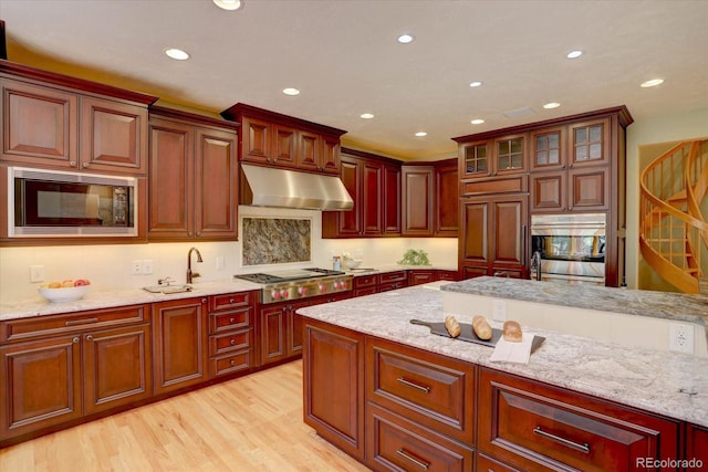 2828 Keystone Dr, Evergreen, CO 80439 - kitchen with under cabinet range hood, built in appliances, recessed lighting, light wood finished floors, and light stone countertops