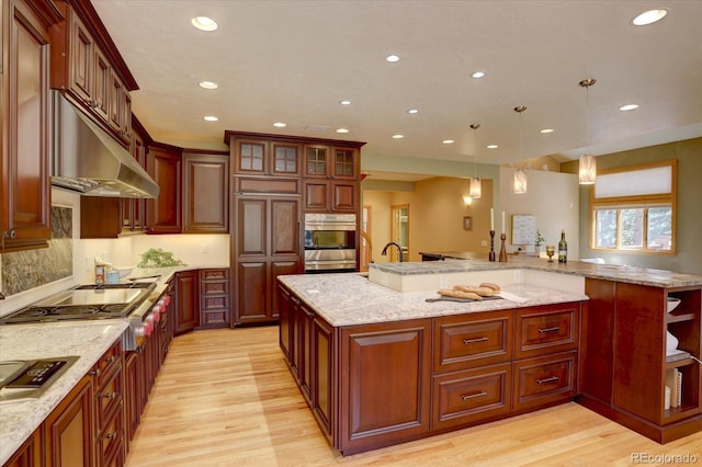 2828 Keystone Dr, Evergreen, CO 80439 - kitchen featuring appliances with stainless steel finishes, light wood finished floors, recessed lighting, hanging light fixtures, and under cabinet range hood