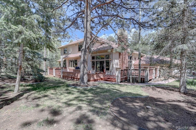 2828 Keystone Dr, Evergreen, CO 80439 - back of property with a chimney, a deck, a lawn, and stucco siding
