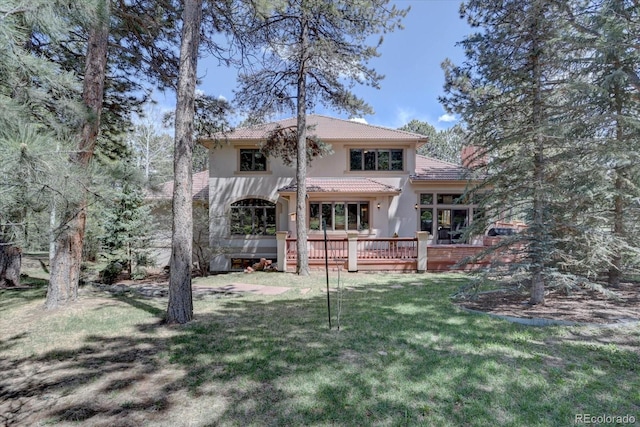 2828 Keystone Dr, Evergreen, CO 80439 - back of property featuring stucco siding, a tiled roof, a wooden deck, and a lawn