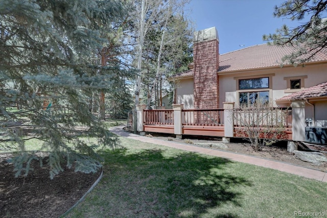2828 Keystone Dr, Evergreen, CO 80439 - back of property featuring a chimney, a wooden deck, stucco siding, and a yard