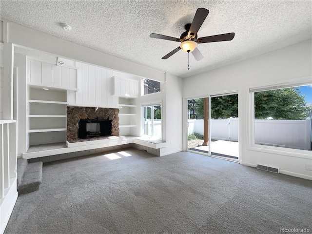 1925 28th Ave Unit 34, Greeley, CO 80634 - unfurnished living room featuring a textured ceiling, carpet, ceiling fan, and a fireplace