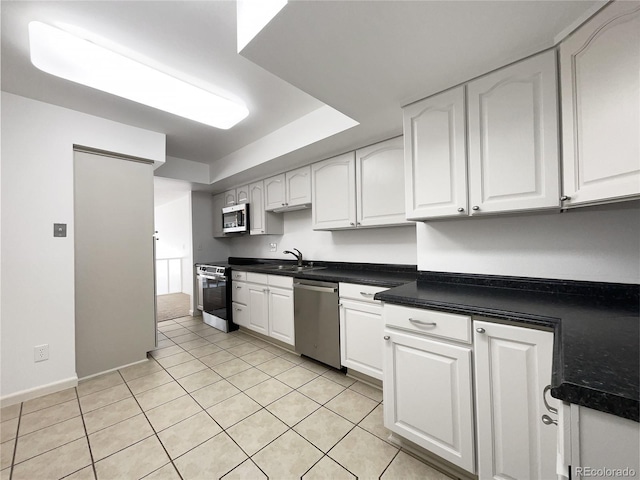 1925 28th Ave Unit 34, Greeley, CO 80634 - kitchen with stainless steel appliances, white cabinets, light tile patterned flooring, and dark countertops