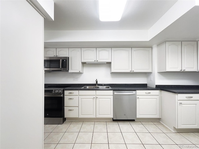 1925 28th Ave Unit 34, Greeley, CO 80634 - kitchen with stainless steel appliances, white cabinetry, light tile patterned flooring, and dark countertops