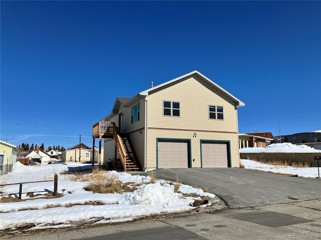 view of front of house featuring stairs, a garage, and driveway