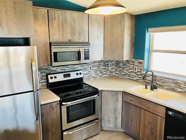 kitchen featuring a sink, light countertops, backsplash, and stainless steel appliances