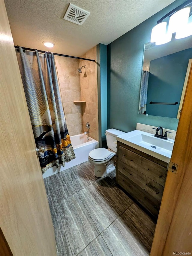 full bath with visible vents, toilet, a textured ceiling, shower / tub combo, and vanity