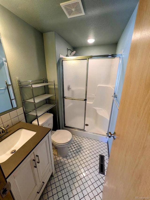 full bathroom with vanity, visible vents, a shower stall, a textured ceiling, and tile patterned floors