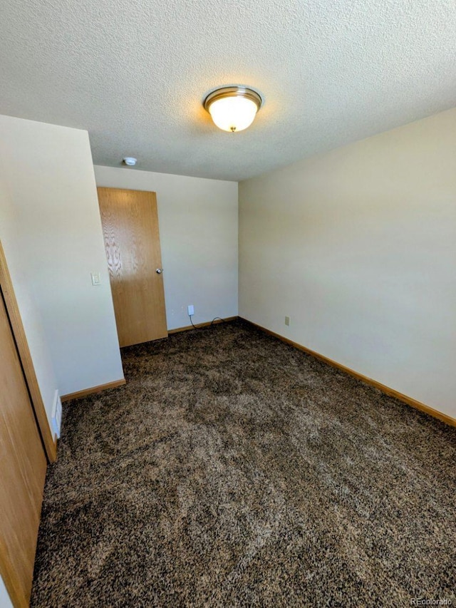 unfurnished bedroom with baseboards, carpet floors, a textured ceiling, and a closet