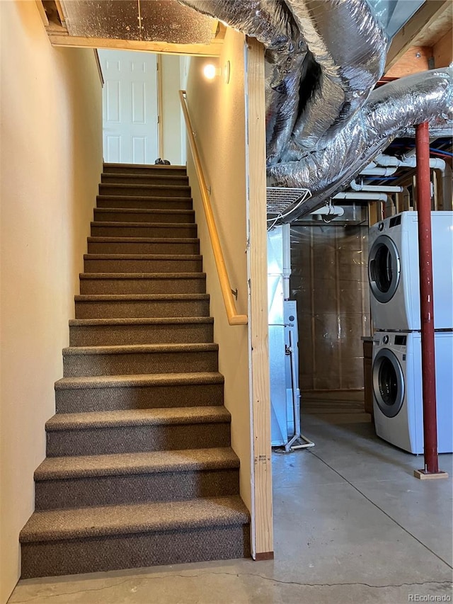 stairway with stacked washer / dryer and concrete flooring