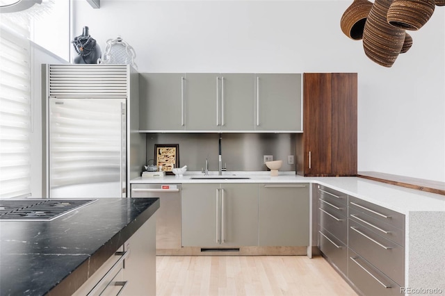 kitchen featuring light hardwood / wood-style floors, stainless steel appliances, sink, and gray cabinets