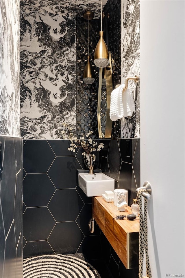 bathroom featuring tile walls and sink