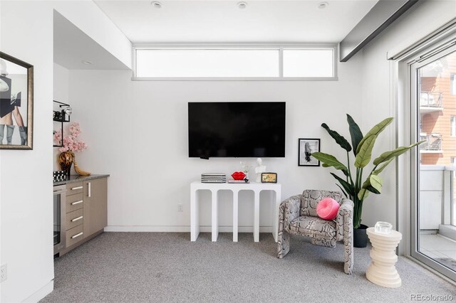 sitting room with beamed ceiling and light colored carpet