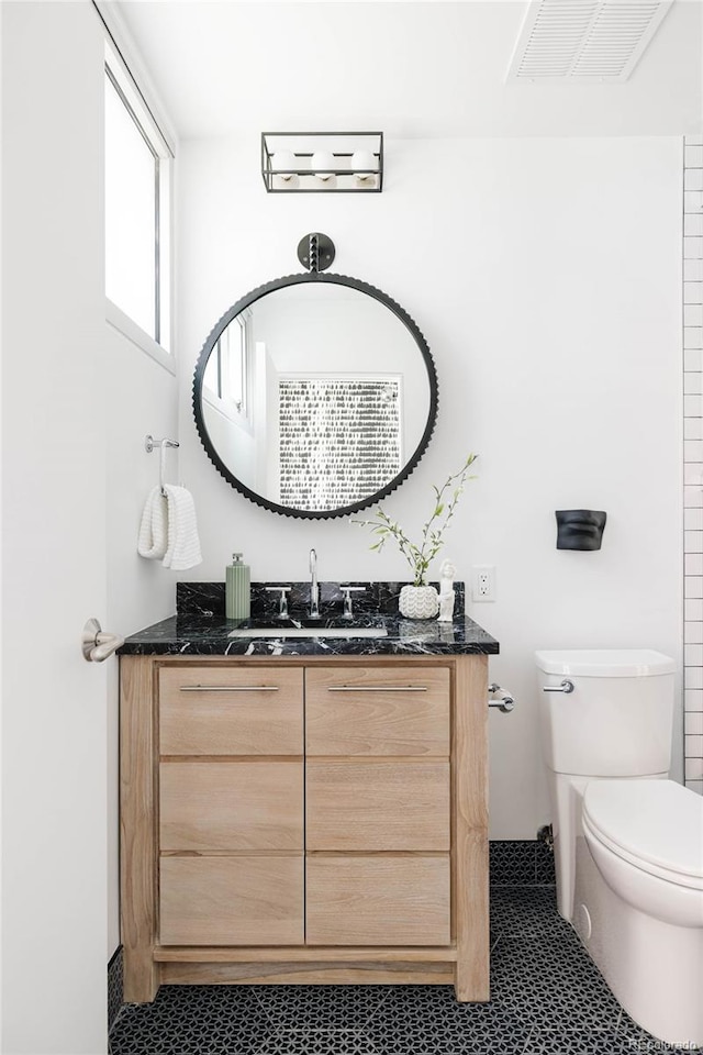 bathroom with vanity, toilet, and tile patterned floors