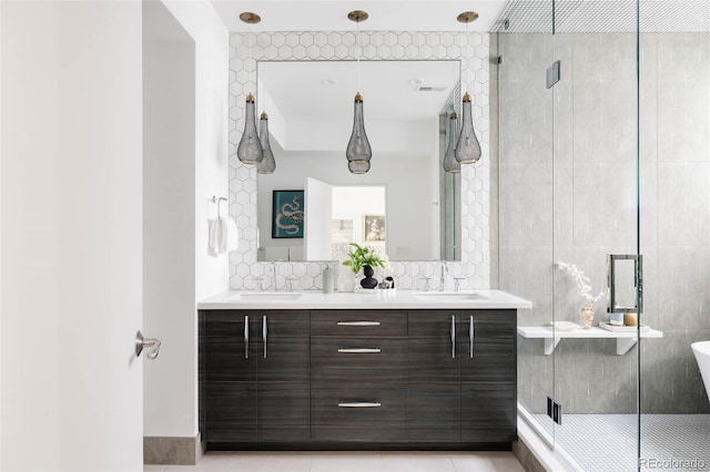 bathroom with tile patterned floors, a stall shower, a sink, tile walls, and double vanity