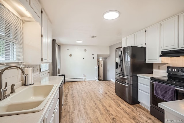 11290 W 77th Dr, Arvada, CO 80005 - kitchen with appliances with stainless steel finishes, under cabinet range hood, a baseboard heating unit, tasteful backsplash, and recessed lighting