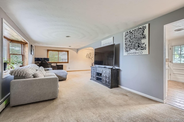 11290 W 77th Dr, Arvada, CO 80005 - living room featuring arched walkways, carpet floors, a baseboard radiator, and an office area