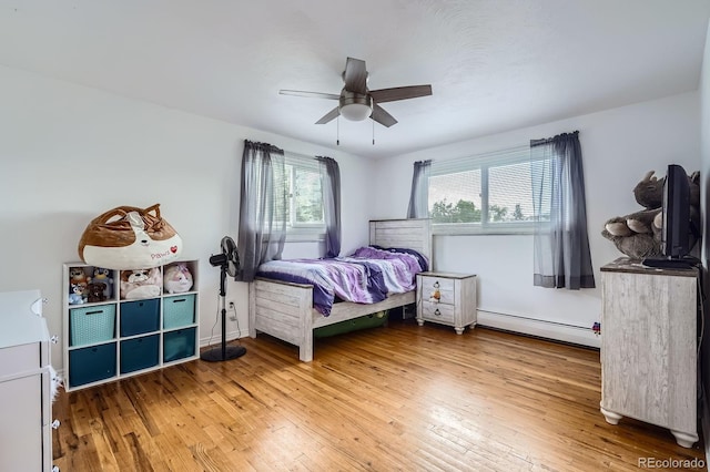 11290 W 77th Dr, Arvada, CO 80005 - bedroom featuring baseboard heating, hardwood / wood-style flooring, and ceiling fan