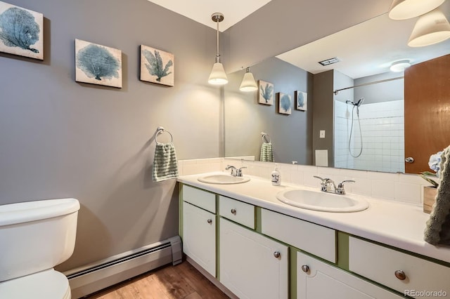 11290 W 77th Dr, Arvada, CO 80005 - bathroom with baseboard heating, double vanity, wood finished floors, and a shower