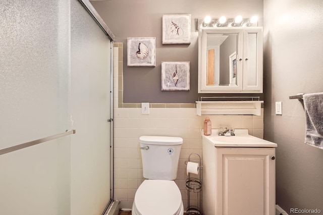 11290 W 77th Dr, Arvada, CO 80005 - bathroom featuring a stall shower, vanity, tile walls, and a wainscoted wall