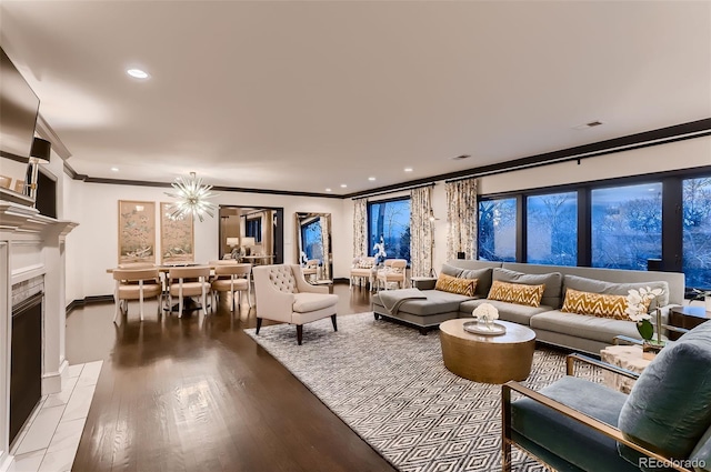 living room with recessed lighting, a fireplace, wood finished floors, baseboards, and ornamental molding