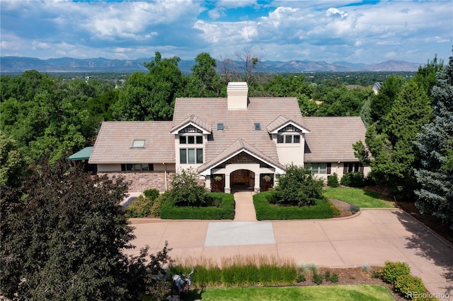 view of front of property featuring a chimney, a tile roof, and a mountain view