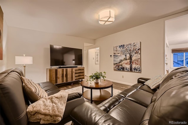 living area featuring baseboards and wood finished floors