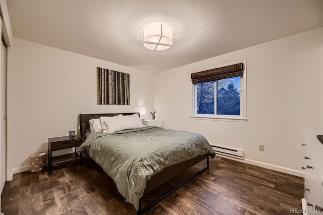 bedroom with dark wood-type flooring, baseboards, and baseboard heating