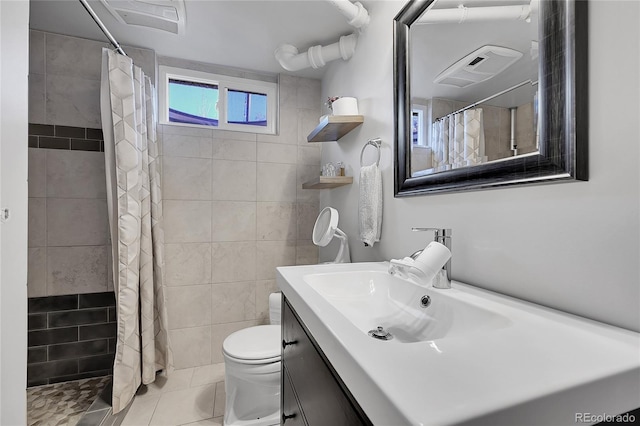 bathroom featuring tile walls, vanity, curtained shower, tile patterned floors, and toilet