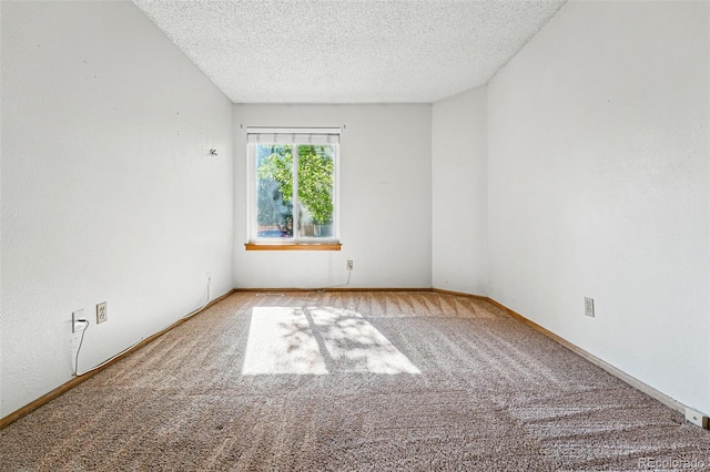 empty room featuring carpet flooring, a textured ceiling, and baseboards