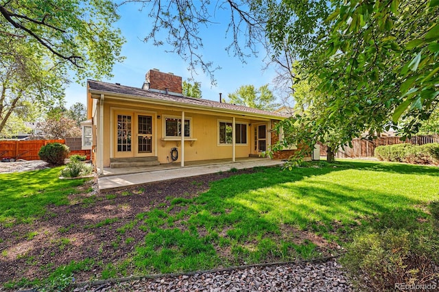 rear view of property with a chimney and a patio area