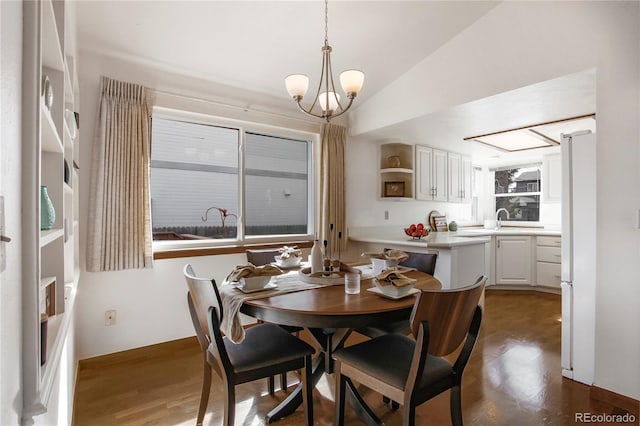 dining room with lofted ceiling, a chandelier, and dark wood finished floors