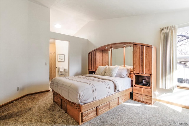 carpeted bedroom featuring lofted ceiling and baseboards