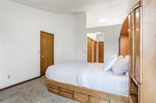 bedroom featuring carpet floors, lofted ceiling, and baseboards