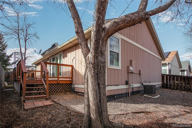 rear view of house with a deck, fence, and central air condition unit