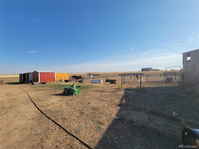 view of yard featuring a rural view and an outbuilding