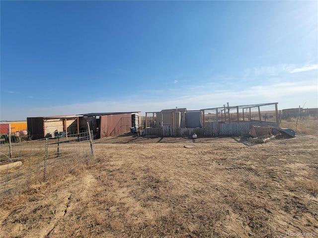 view of yard featuring a rural view and an outdoor structure