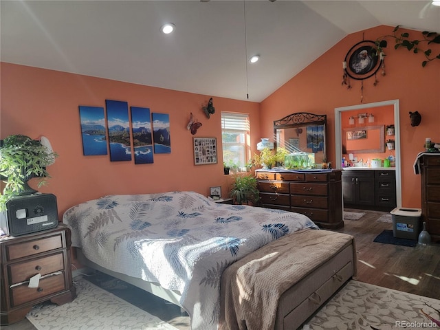 bedroom featuring lofted ceiling, hardwood / wood-style flooring, and ensuite bath