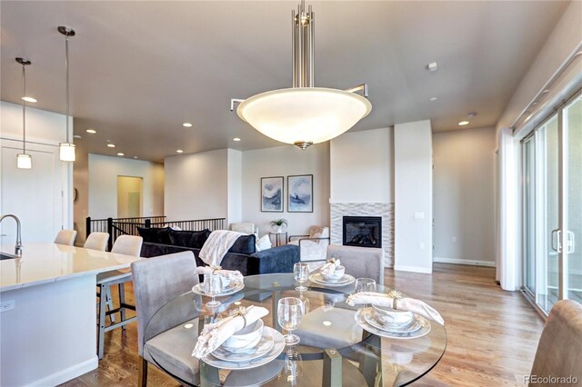 365 Casalon Pl, Superior, CO 80027 - dining room featuring light wood-style flooring, a glass covered fireplace, recessed lighting, and baseboards