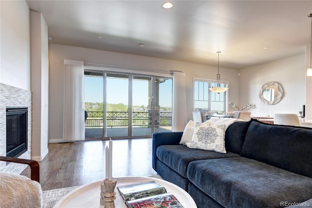 365 Casalon Pl, Superior, CO 80027 - living room featuring wood finished floors, baseboards, a stone fireplace, and recessed lighting