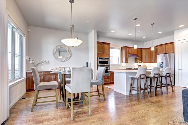 365 Casalon Pl, Superior, CO 80027 - kitchen with appliances with stainless steel finishes, light countertops, brown cabinetry, light wood finished floors, and recessed lighting
